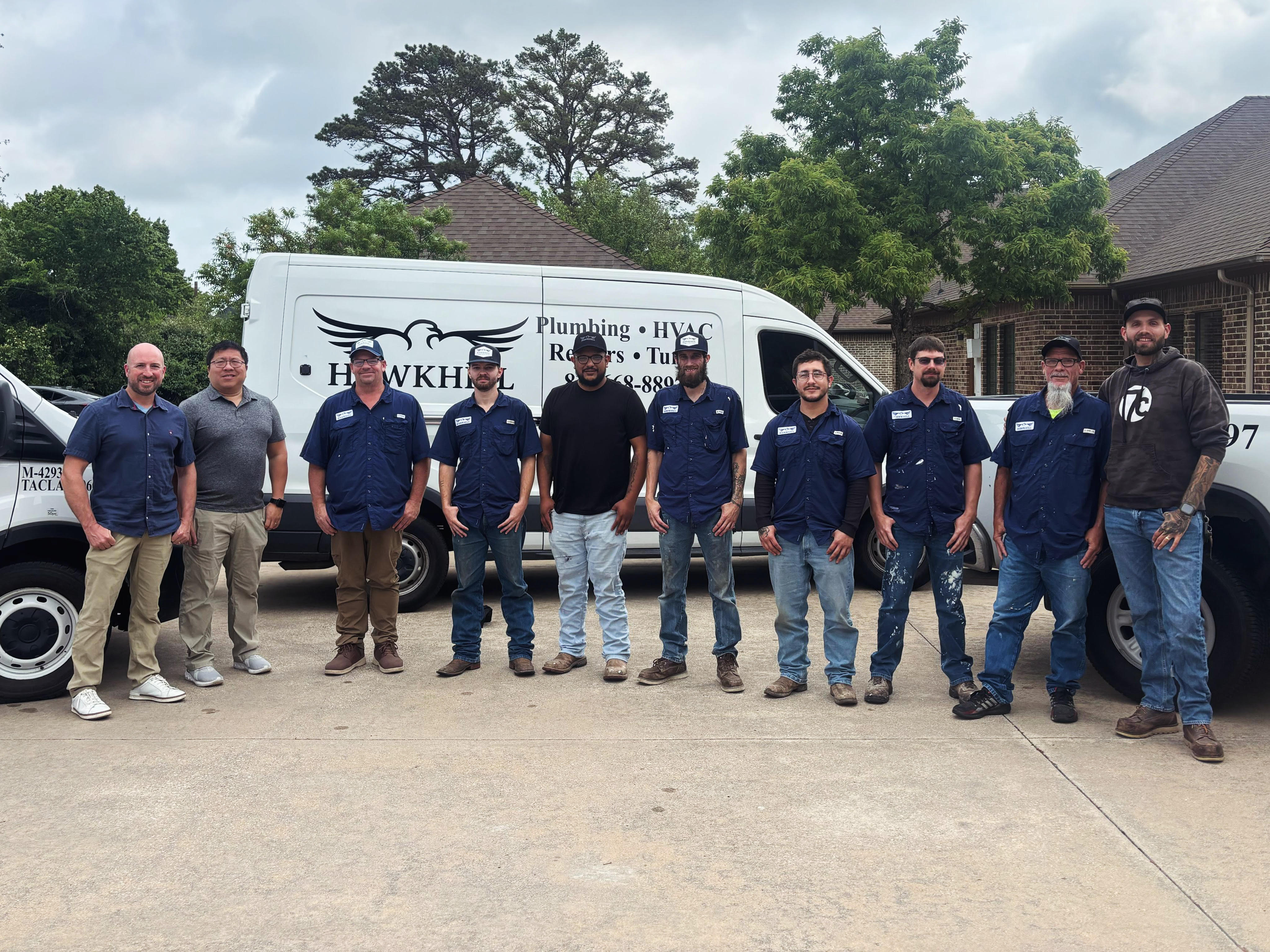 The Hawkhill Property Services team in front of company vehicles